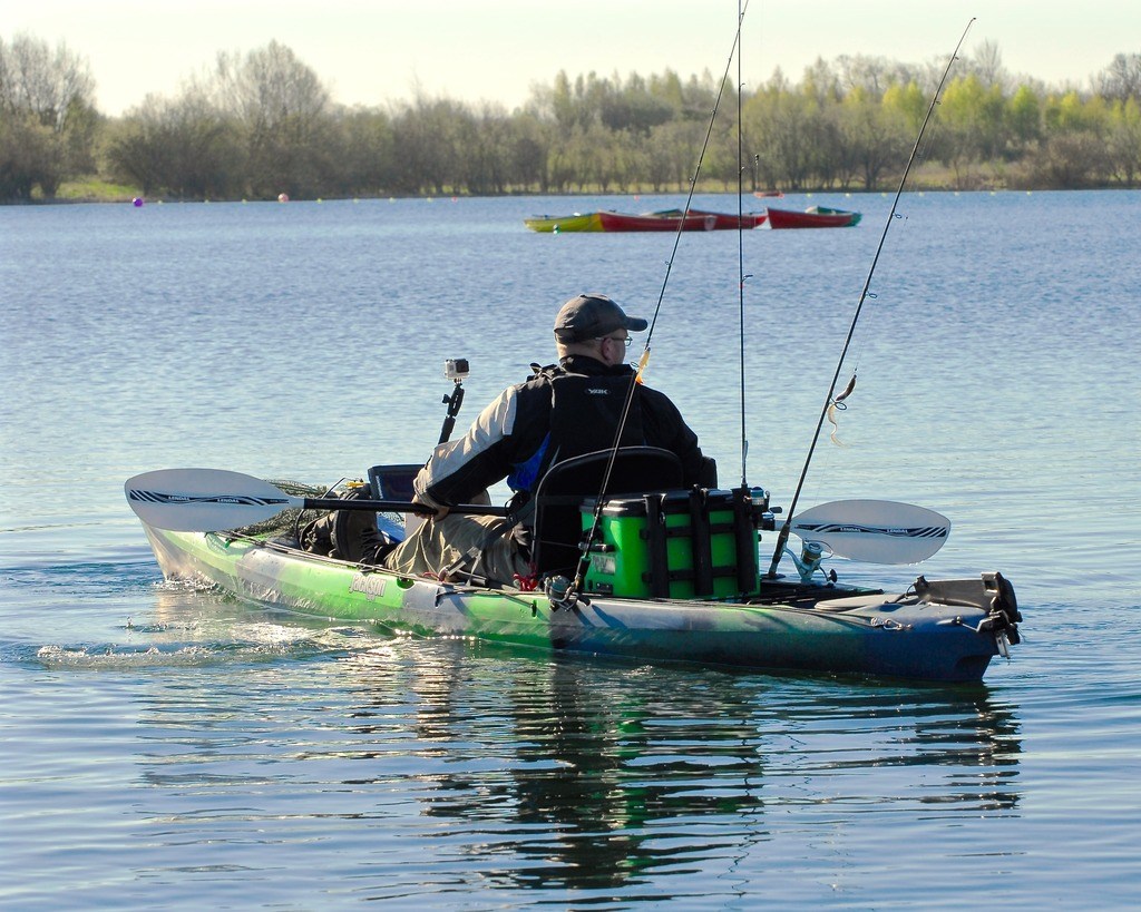 A fisherman heads out onto the water with some of the top bass fishing baits for kayak fishing.